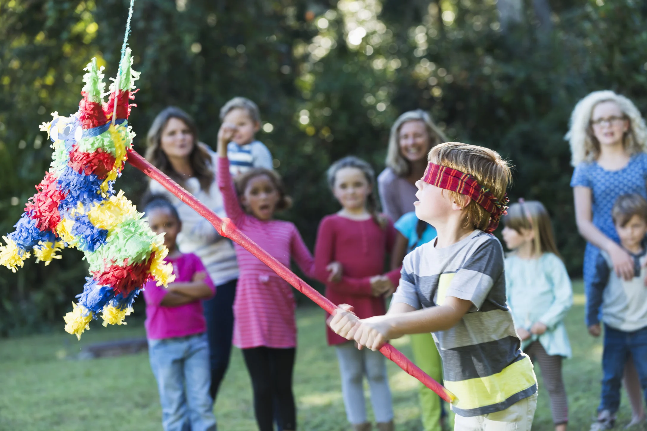 kids playing with a pinata at a park